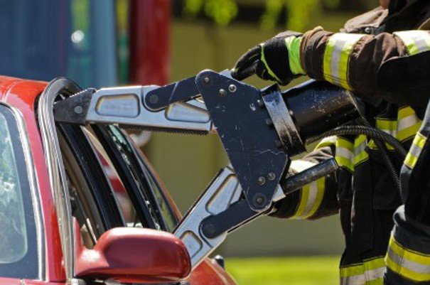 Jaws of life working on a red car.
