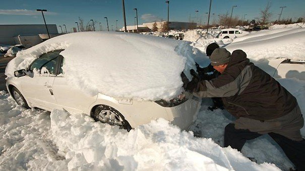 Pushing car stuck in the snow.