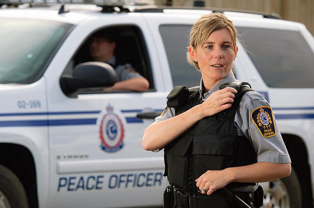 A police officer in front of her police vehicle.